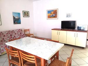 sala de estar con mesa y sofá en Fides Apartment, en Rosolina Mare