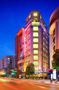 a tall building with neon signs on the side of it at Luxeden Hotel in Hanoi