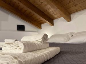 2 bedden in een kamer met witte lakens bij Comfort Room 1 Dogana Svizzera in San Fermo della Battaglia