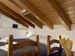 2 bedden in een kamer met houten plafonds bij Comfort Room 1 Dogana Svizzera in San Fermo della Battaglia