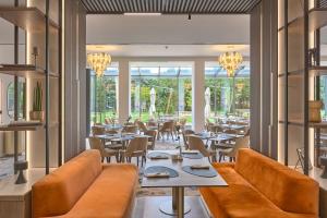 un restaurant avec des sièges et des tables en cuir brun dans l'établissement Hotel Imperial Plovdiv, a member of Radisson Individuals, à Plovdiv