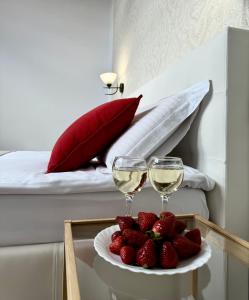 two glasses of wine and strawberries on a table in a bedroom at Villa Alessia in Skhidnitsa