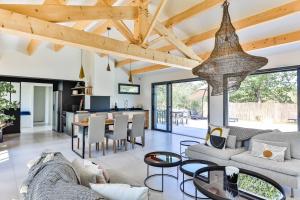 cocina abierta y sala de estar con techos de madera. en Chiron Reculeau - Maison avec piscine, en Bois-de-Cené