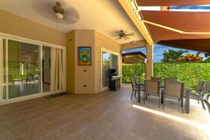 a patio with a table and chairs on it at Villa Jardin By Vacation Pura Vida in Esterillos