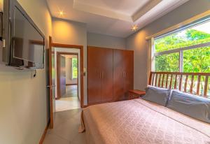 a bedroom with a bed and a large window at Villa Jardin By Vacation Pura Vida in Esterillos +51 photos