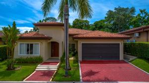 a house with a palm tree and a garage at Villa Jardin By Vacation Pura Vida in Esterillos