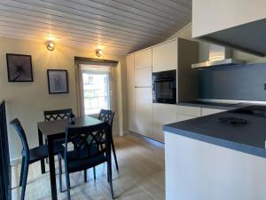 a kitchen and dining room with a table and chairs at Argegno's River - Central Apartment lake view in Argegno
