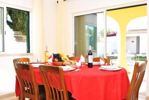 a table with a red table cloth and a bottle of wine at Villa La Romana by Algarve Vacation in Albufeira