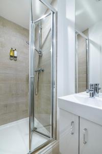 a shower with a glass door in a bathroom at Franco's in Sudbury