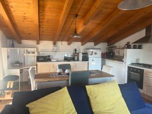 eine Küche mit weißen Geräten sowie einem Tisch und Stühlen in der Unterkunft Villa Ai Colli in Salò