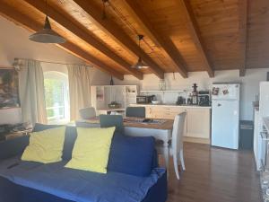 a living room with a blue couch and a kitchen at Villa Ai Colli in Salò