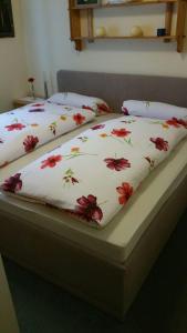 a couple of beds with red flowers on them at Ferienwohnung Auszeit in Fischen +18 photos