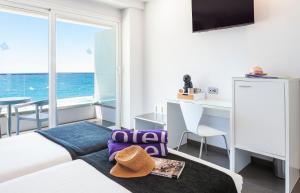 een slaapkamer met een bed en een bureau met uitzicht op de oceaan bij Hotel Brisa in Benidorm
