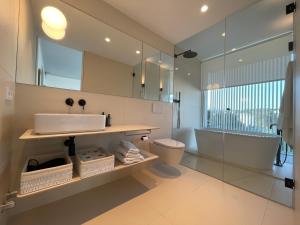 een badkamer met een wastafel, een bad en een spiegel bij Holiday Rentals at Camiral Golf & Wellness in Caldes de Malavella