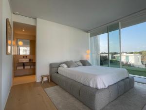 - une chambre avec un lit et une grande fenêtre dans l'établissement Holiday Rentals at Camiral Golf & Wellness, à Caldes de Malavella