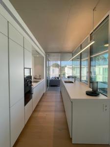 een open keuken met witte kasten en een groot raam bij Holiday Rentals at Camiral Golf & Wellness in Caldes de Malavella