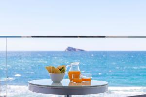 Hotel Brisa في بنيدورم: طاولة مع كأسين وزجاجة من عصير البرتقال