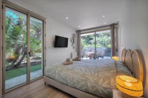 een slaapkamer met een bed en een glazen schuifdeur bij Le Greg - Terrasse - Parking - VCA in Cannes +34 foto's