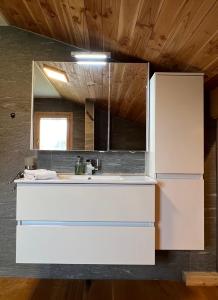 La cuisine est équipée d'un réfrigérateur blanc et d'un évier. dans l'établissement Cozy Apartment With Stunning View, à Gsteig