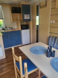 una cocina con una mesa con placas azules. en Camping Riva Bella - Mobil home Les4L, en Ouistreham