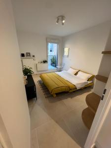 a bedroom with a bed with a yellow blanket at Studio indépendant avec terrasse in Villejuif