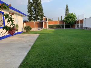 een grote tuin met een gebouw en een gazon bij Casa en Oaxtepec in Oaxtepec