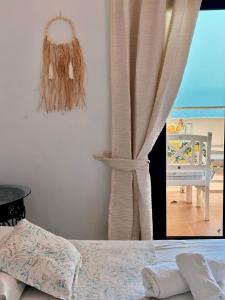 a bedroom with a bed and a window with a curtain at Hotel Imperial in Dhërmi