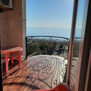 a balcony with a table and a view of the ocean at Hotel Kvariati Nugo in Kvariati