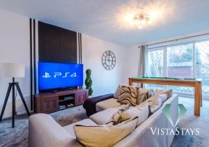 ein Wohnzimmer mit einem Sofa und einem TV in der Unterkunft NEW Modern 4 Bed Property with Pool Table in Manchester by Vista Stays in Manchester