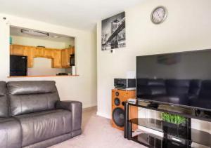 uma sala de estar com um sofá e uma televisão de ecrã plano em Two Bedroom Apartment in Norwood em Norwood