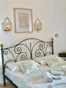 - un lit avec deux oreillers et une photo sur le mur dans l'établissement Hotel Imperial, à Dhërmi