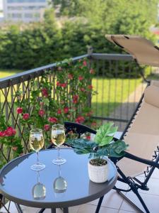two glasses of wine on a table on a balcony at Zielony Zakątek z balkonem in Koszalin