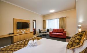 um quarto de hotel com uma cama e uma televisão em Best Western Mahoneys Motor Inn em Melbourne