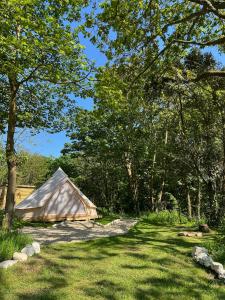 uma tenda num campo com árvores e relva em Glamping at Camp Corve em Chale