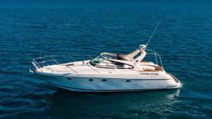 a man sitting on a white boat in the water at Starboard Charter in Nikiana