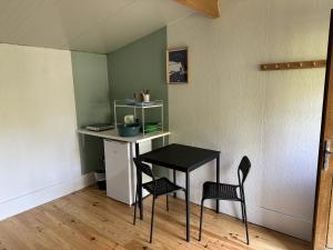 a small table and two chairs in a room at Etretat Aventure in Les Loges