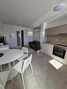 a kitchen and living room with a white table and chairs at Luni in Zadar