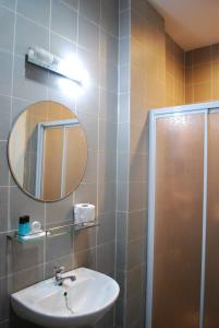 a bathroom with a sink and a mirror and a shower at Akar Beach Resort in Port Dickson