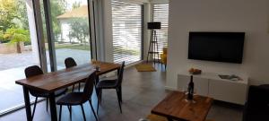 a dining room with a table and chairs and a television at Seabreeze Luxury Apartments in Njivice