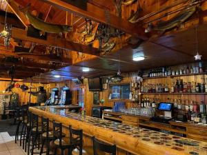 um bar com um grande balcão de madeira com bancos de bar em Gresham Shores-Hungry Bear em Arbor Vitae