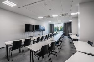 a classroom with tables and chairs and a flat screen tv at EA Congress Hotel Aldis in Hradec Králové