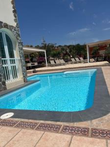 une grande piscine bleue dans une maison dans l'établissement Casa Macken con piscina climatizada y jacuzzi, à San Bartolomé