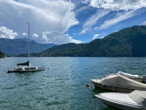 zwei Boote auf einem See mit Bergen im Hintergrund in der Unterkunft Life is Good - Front Lake Apartment in Villa in Tremezzo