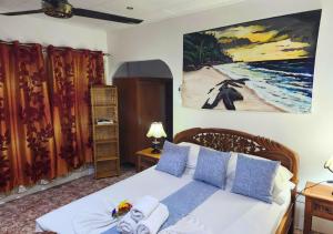 Schlafzimmer mit einem Bett mit Wandgemälde in der Unterkunft Buisson Guesthouse in La Digue