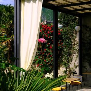 a patio with an umbrella and a table and flowers at Residenza Laurum B&B in Mandello del Lario