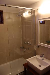 uma casa de banho com um chuveiro, um lavatório e uma banheira em Valle Frío Ushuaia em Ushuaia