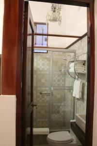 a bathroom with a toilet and a glass shower at Epoca Iquitos in Iquitos