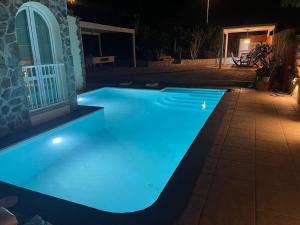 a swimming pool lit up at night with blue lights at Casa Macken con piscina climatizada y jacuzzi in San Bartolomé