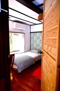 a small bedroom with a bed and a window at Birdland Nature Resort - Vacation STAY 12454 in Akaoki