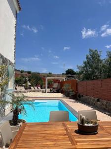 - une table en bois avec des chaises à côté de la piscine dans l'établissement Casa Macken con piscina climatizada y jacuzzi, à San Bartolomé